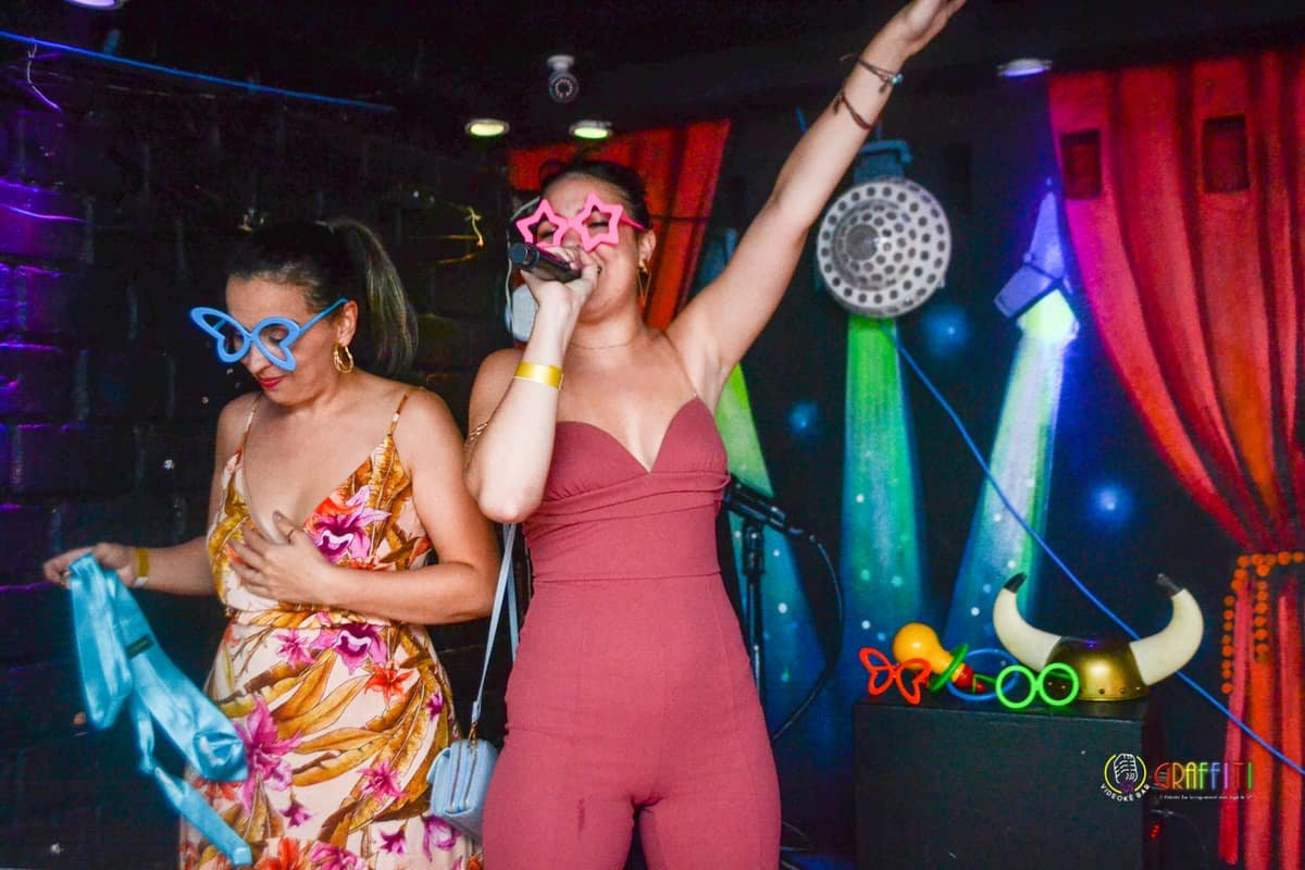 Amigas cantando no palco do Graffiti Bar Karaokê