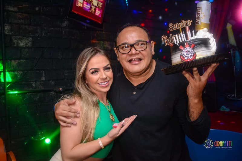 Aniversariante com bolo e amigos no Graffiti